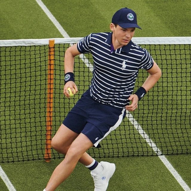 A ball boy running across a tennis court